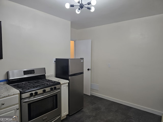 kitchen featuring white cabinets, appliances with stainless steel finishes, and a chandelier