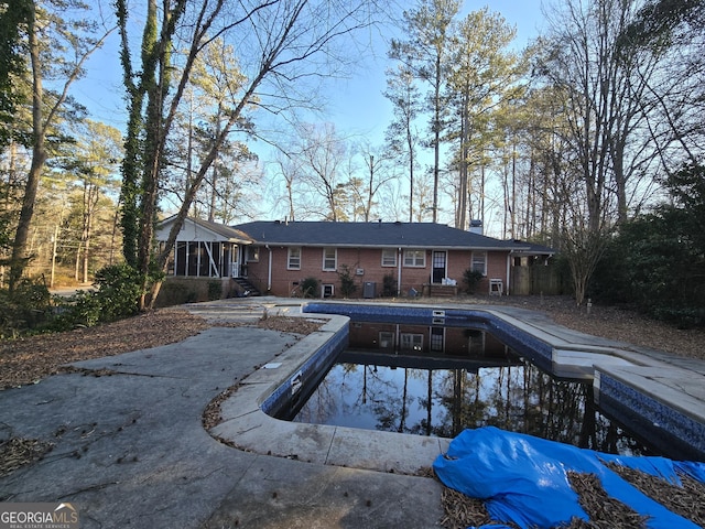 view of pool featuring a patio area and a sunroom