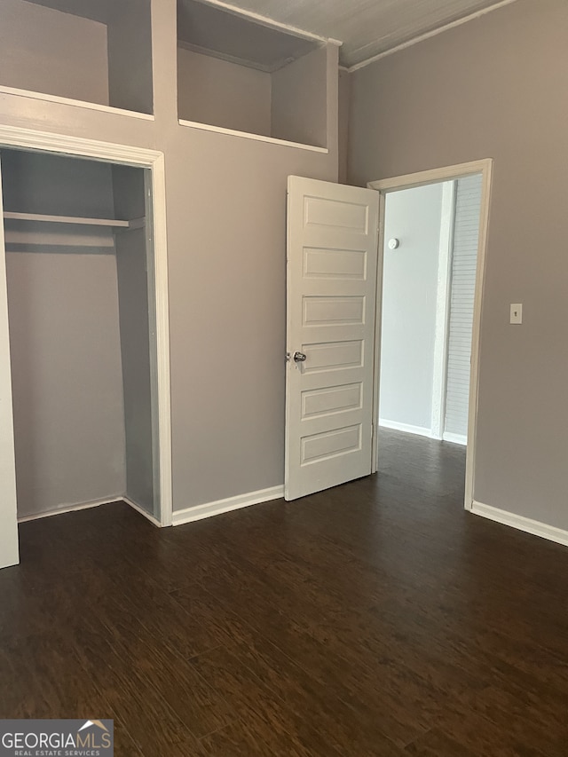 unfurnished bedroom featuring dark hardwood / wood-style floors, a closet, and crown molding