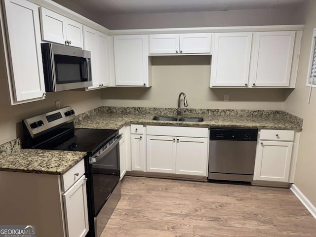 kitchen with white cabinets, appliances with stainless steel finishes, and sink