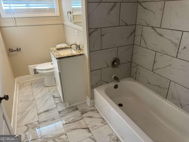 full bathroom with vanity, tiled shower / bath combo, and toilet