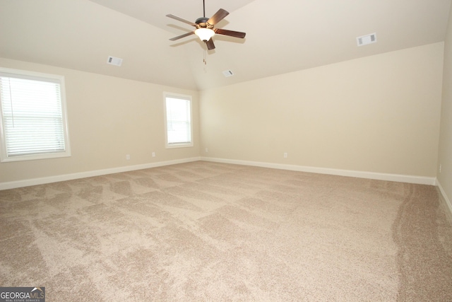 spare room with ceiling fan, light colored carpet, and lofted ceiling