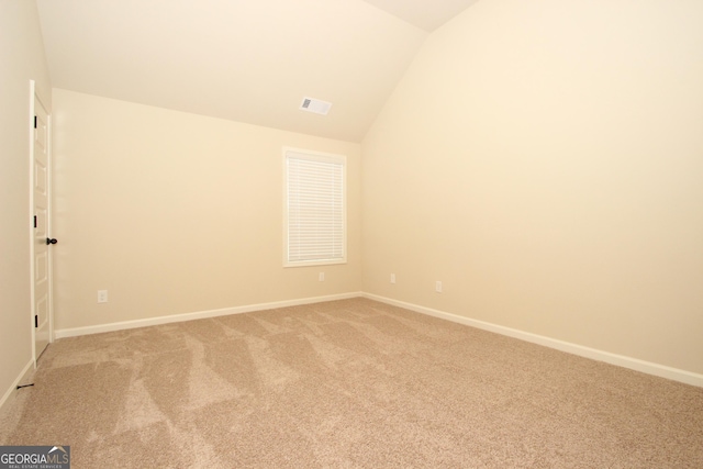 empty room featuring carpet and lofted ceiling