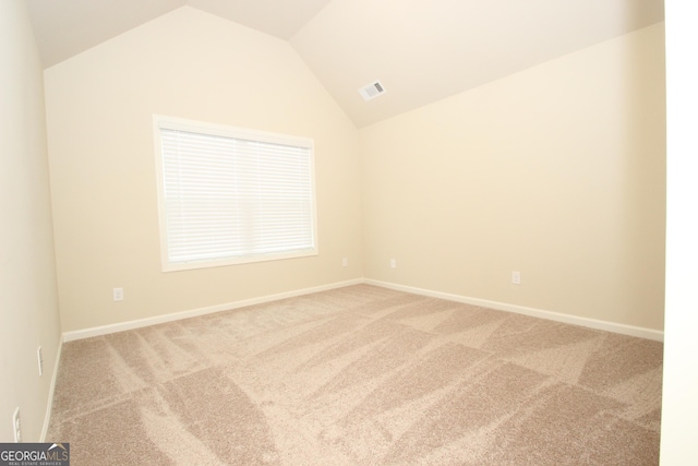 carpeted empty room with lofted ceiling