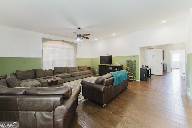 living room with ceiling fan and dark wood-type flooring