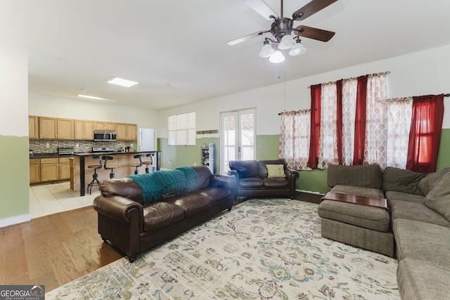 living room with light hardwood / wood-style flooring and ceiling fan