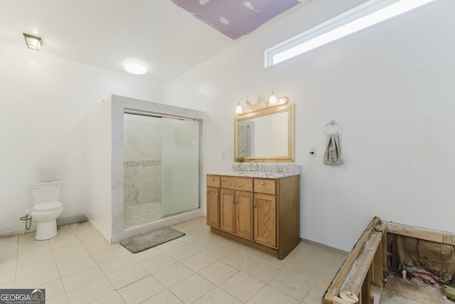 bathroom featuring tile patterned floors, vanity, toilet, and walk in shower