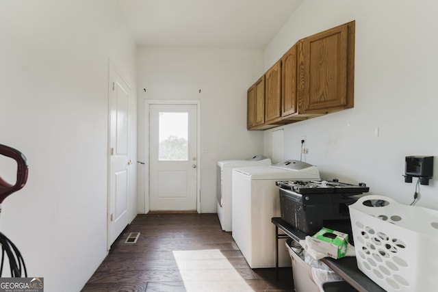 laundry area featuring cabinets, washing machine and dryer, and dark hardwood / wood-style floors