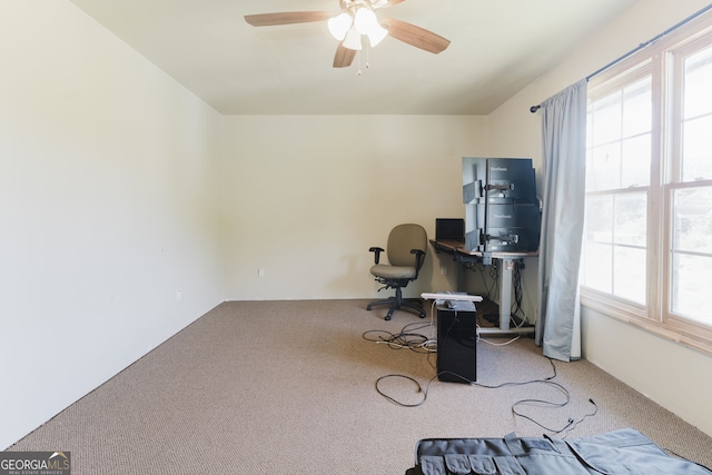 carpeted office space with ceiling fan