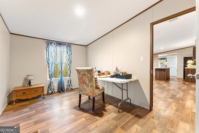 office area featuring a textured ceiling, light wood-type flooring, lofted ceiling, and ornamental molding