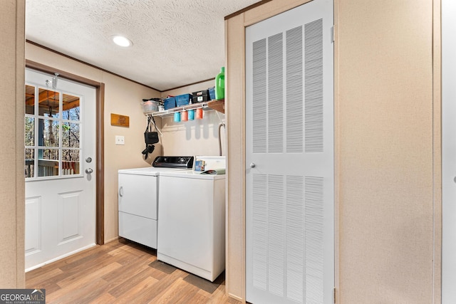 washroom featuring light hardwood / wood-style floors, separate washer and dryer, and a textured ceiling