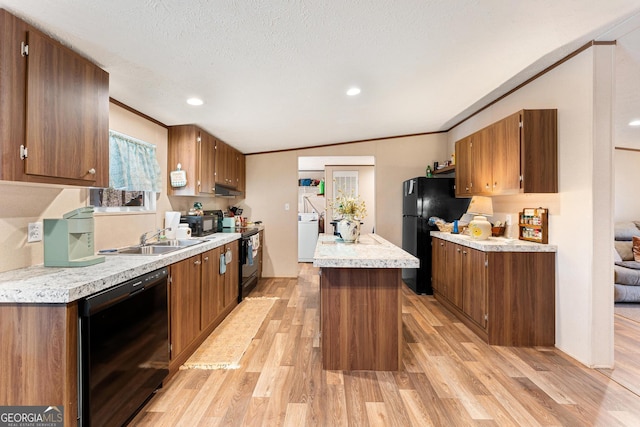 kitchen with ornamental molding, sink, black appliances, light hardwood / wood-style flooring, and a center island