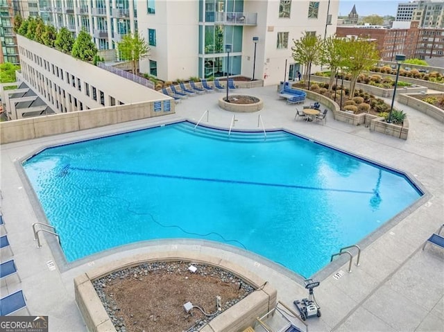 pool featuring an outdoor fire pit and a patio area