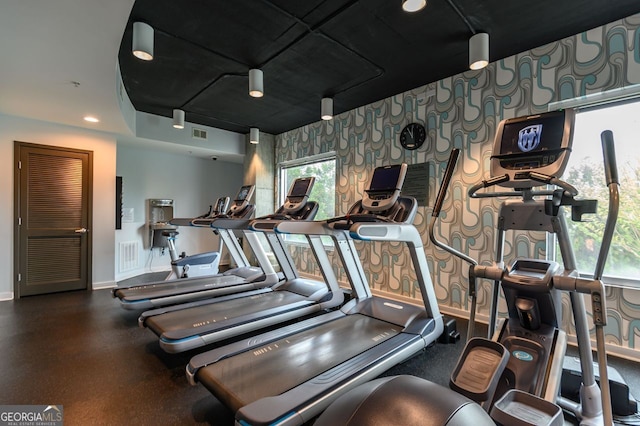 gym with wallpapered walls, visible vents, an accent wall, and baseboards