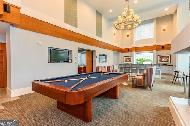 rec room with an inviting chandelier, carpet floors, a towering ceiling, and billiards