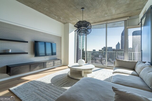 living room featuring plenty of natural light, hardwood / wood-style floors, and an inviting chandelier