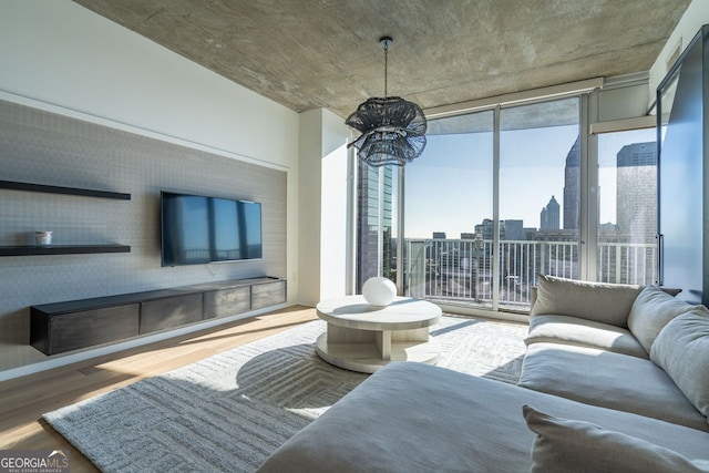 living area with a wall of windows, wood finished floors, and a notable chandelier