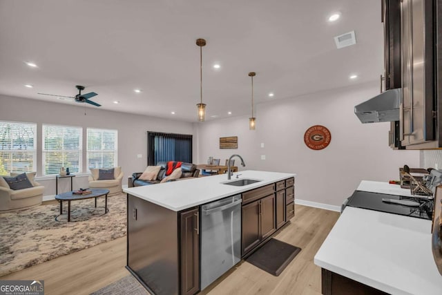 kitchen with stainless steel dishwasher, sink, exhaust hood, hanging light fixtures, and an island with sink