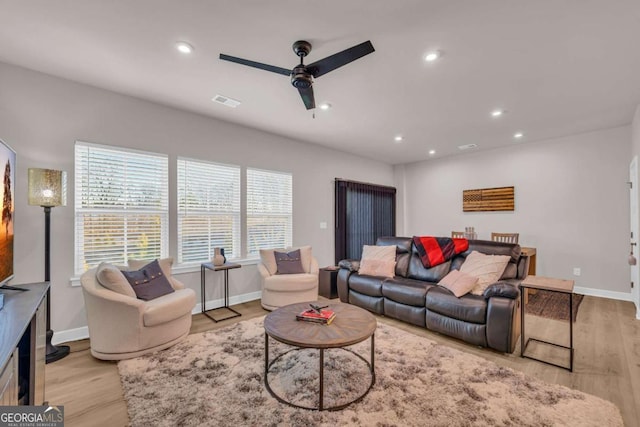 living room featuring light hardwood / wood-style floors and ceiling fan