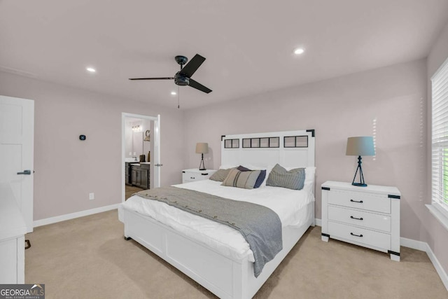 bedroom featuring connected bathroom, ceiling fan, light carpet, and multiple windows