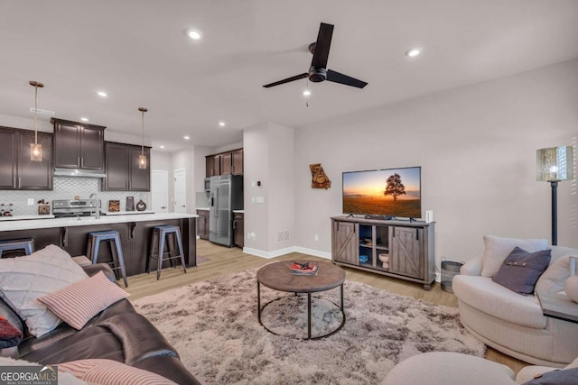 living room featuring light wood-type flooring and ceiling fan