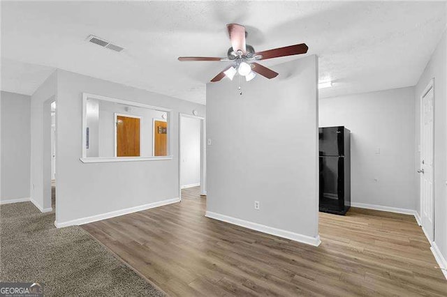 unfurnished living room featuring ceiling fan and wood-type flooring