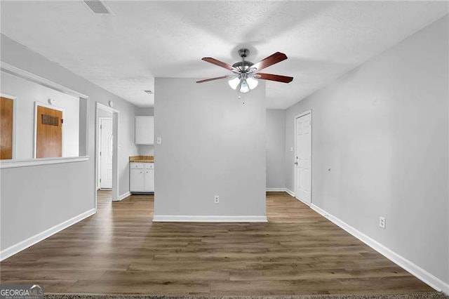 spare room featuring dark hardwood / wood-style flooring, a textured ceiling, and ceiling fan