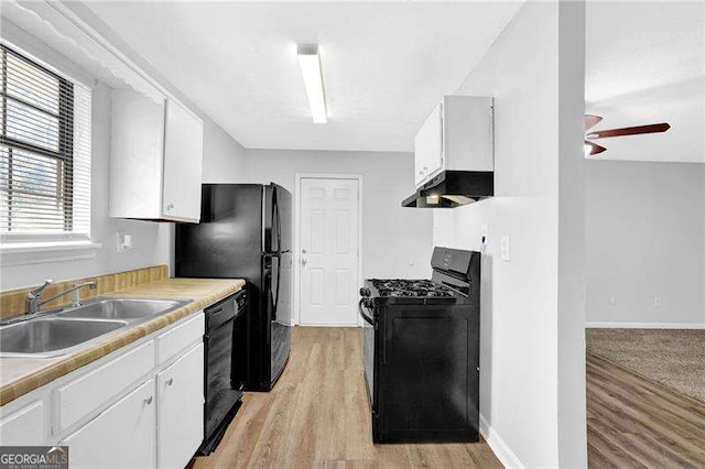 kitchen with black appliances, white cabinetry, and sink