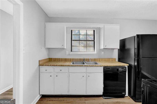 kitchen featuring sink, white cabinets, black appliances, and a textured ceiling