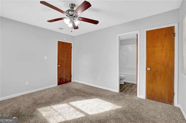 unfurnished bedroom featuring carpet, ensuite bathroom, and ceiling fan