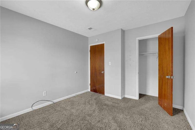 unfurnished bedroom featuring carpet flooring and a closet