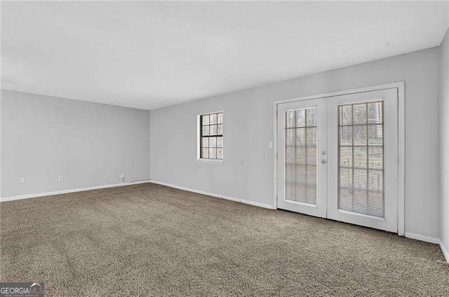 unfurnished room featuring french doors and carpet floors