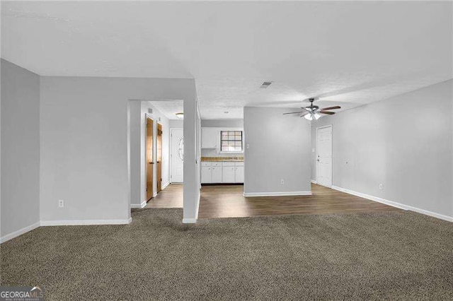 spare room with dark colored carpet and ceiling fan