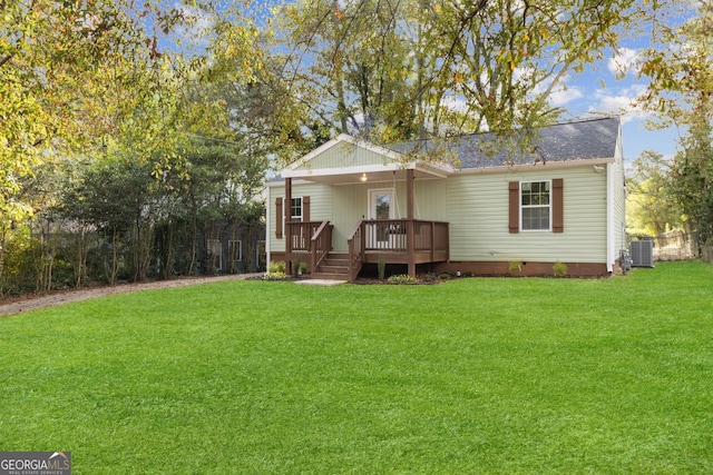 back of property with central air condition unit and a lawn