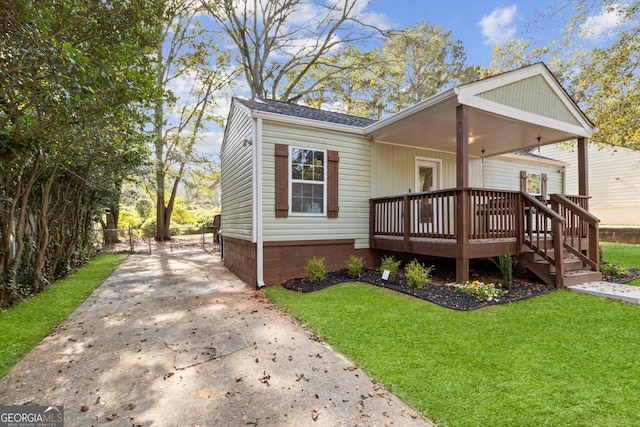 view of front of home with a deck and a front lawn