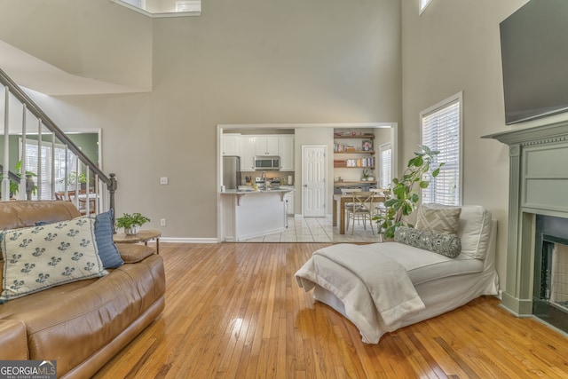 living room with a towering ceiling and light hardwood / wood-style floors