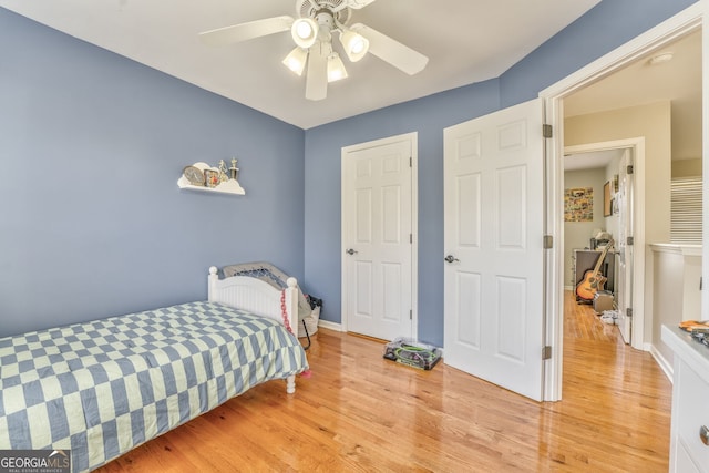 bedroom with light hardwood / wood-style flooring and ceiling fan