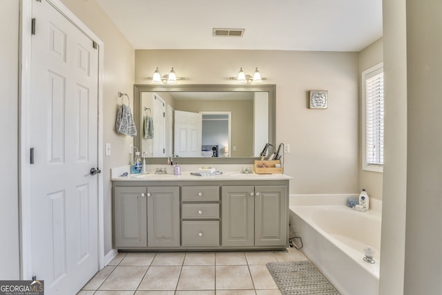 bathroom with tile patterned flooring, vanity, and a bath