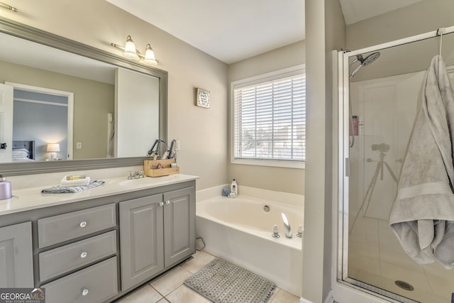 bathroom with tile patterned flooring, shower with separate bathtub, and vanity