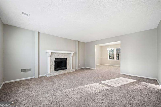 unfurnished living room featuring carpet floors, a textured ceiling, and an inviting chandelier