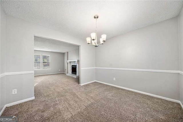 unfurnished living room featuring carpet floors, a chandelier, and a textured ceiling