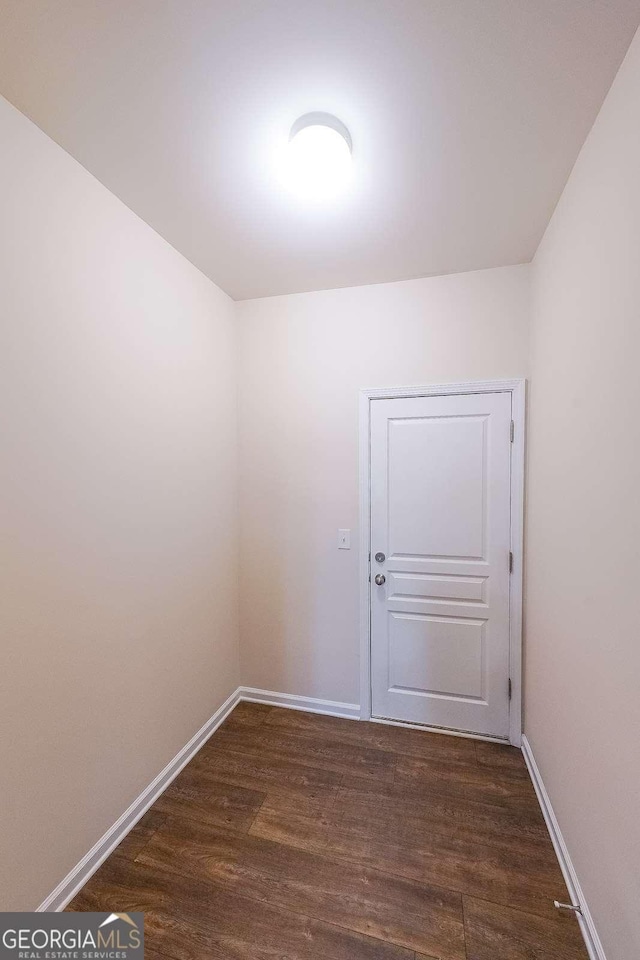 unfurnished room with dark wood-type flooring