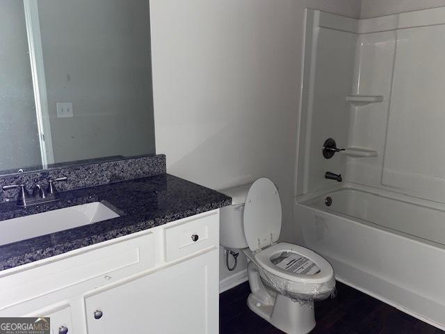 full bathroom featuring vanity, toilet, wood-type flooring, and bathing tub / shower combination