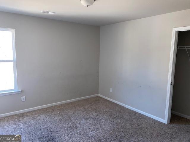 unfurnished bedroom featuring carpet flooring and a closet