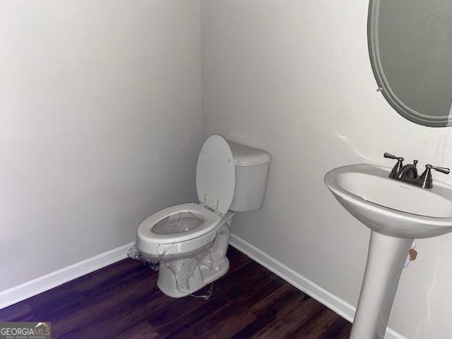 bathroom with toilet, wood-type flooring, and sink