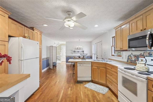 301 Benson Rd, Dallas, GA 30132 - kitchen with light wood-type flooring, a textured ceiling, white appliances, sink, and decorative light fixtures