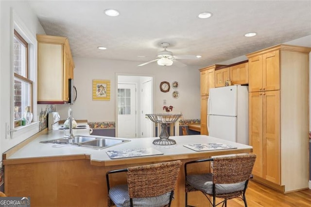 301 Benson Rd, Dallas, GA 30132 - kitchen featuring sink, white refrigerator, kitchen peninsula, a kitchen bar, and light wood-type flooring