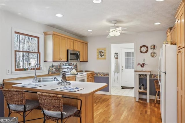 301 Benson Rd, Dallas, GA 30132 - kitchen with white appliances, sink, ceiling fan, light hardwood / wood-style floors, and kitchen peninsula
