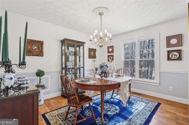 301 Benson Rd, Dallas, GA 30132 - dining area featuring hardwood / wood-style floors, a textured ceiling, and an inviting chandelier