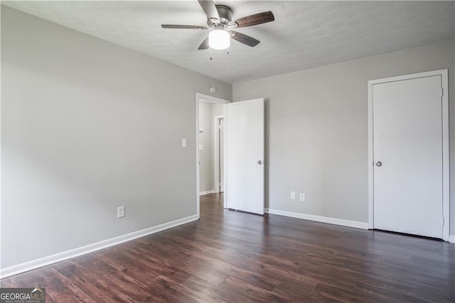 unfurnished bedroom featuring dark wood-type flooring, a textured ceiling, and ceiling fan